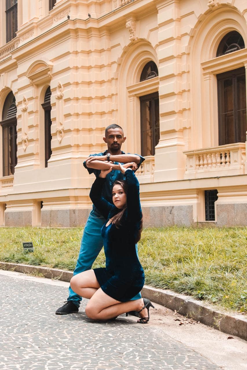 Casal dançando na frente de um casarão
